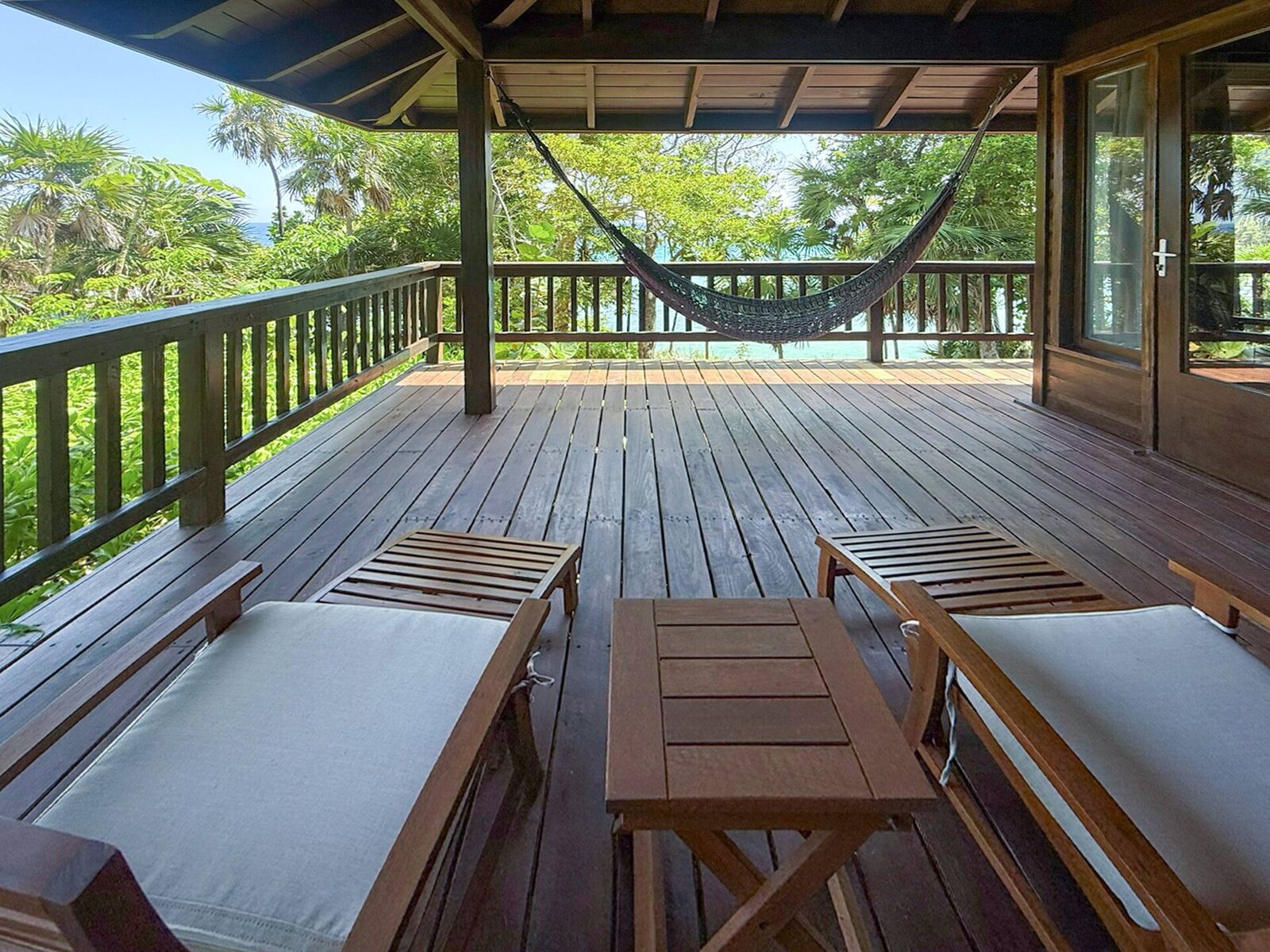 Private wooden balcony deck with a hammock and ocean view
